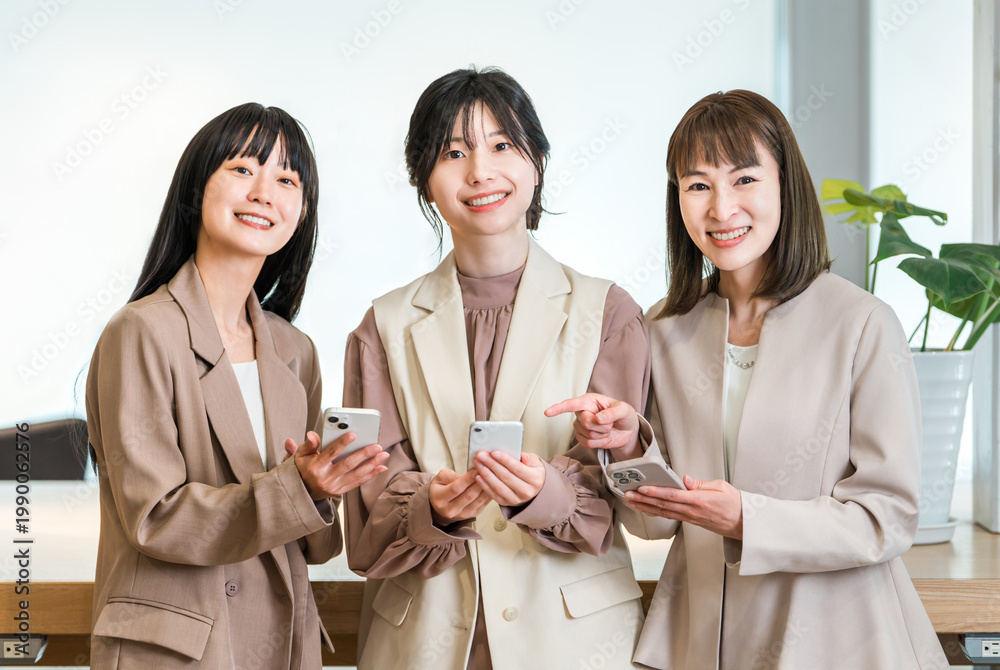 © buritora - A businesswoman in the office using her smartphone (searching, booking, consulting, meeting).