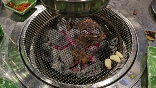 Grilling meat over charcoal at a restaurant