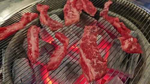 Grilling meat over charcoal at a restaurant