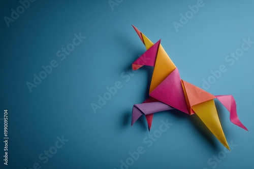 Colorful paper unicorn origami figure on a solid blue background.