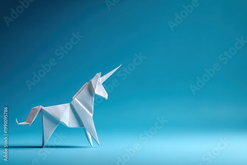 White paper unicorn origami figure against a solid blue background.