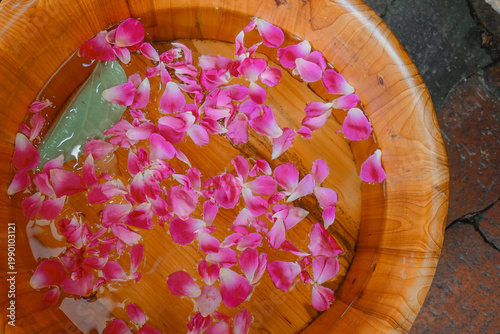 spa concept. flowers in bowl with water on wooden background. beautiful flowers on background, close up
