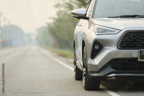 A modern SUV is parked along a quiet roadside in soft morning light, with a misty background creating a calm and scenic atmosphere, highlighting travel, mobility, and peaceful rural journeys.