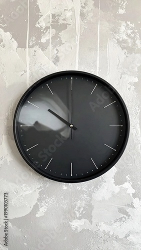 Minimalist black round wall clock with white dashes on a textured grey concrete background, time management, schedule, efficiency, deadline