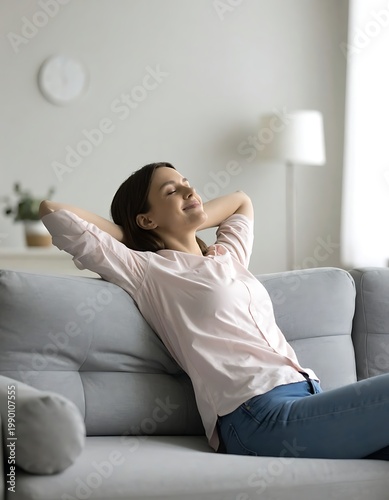 A woman relaxing on a couch with her hands behind her head
