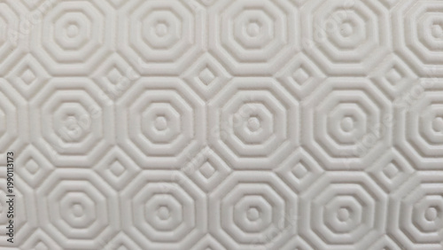 Light colored textured surface displaying a repeating geometric arrangement of.