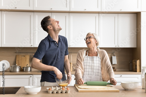 Принти на полотні Untroubled multigenerational family, grown-up son and mature mother cooking, sha