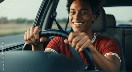 Young African American man happily driving a car on a sunny day.
