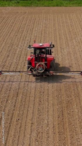 Aerial view tractor spraying herbicides fungicides insecticides field