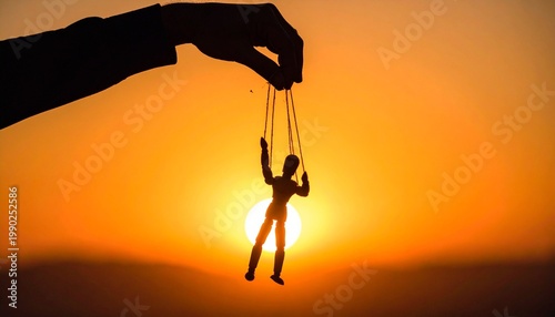 Silhouette hand holding puppet against vivid orange sunset backdrop