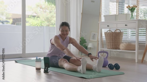 Young active asia people woman using smart phone watch learn online AI gym class home workout video app Health care sport club internet of things happy relax enjoy yoga anti aging life weight loss.