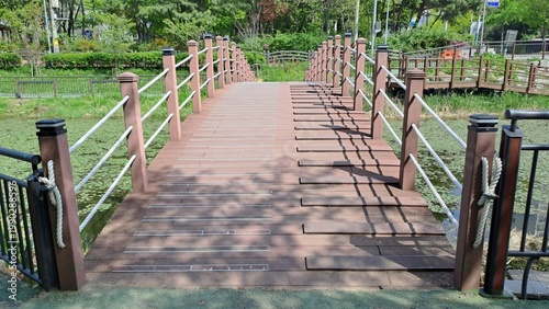Wooden bridge over a pond in a public park during spring