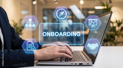 Businessman using laptop with digital onboarding interface icons in office