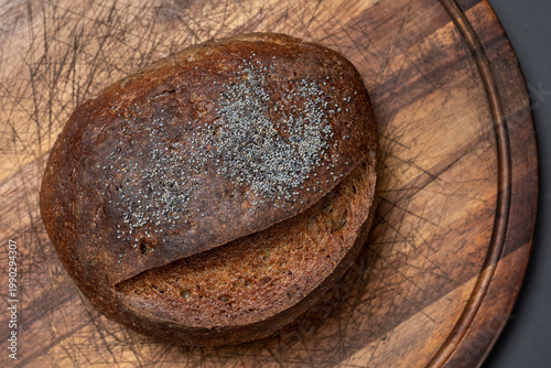 Top view of artisan bread loaf on wooden board, rustic bakery style