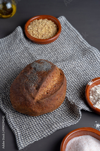 Artisan bread with grains and flour ingredients, rustic kitchen composition