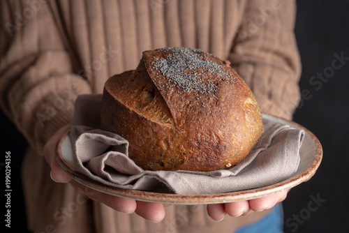 Fresh baked artisan bread served on plate with cloth, cozy homemade concept