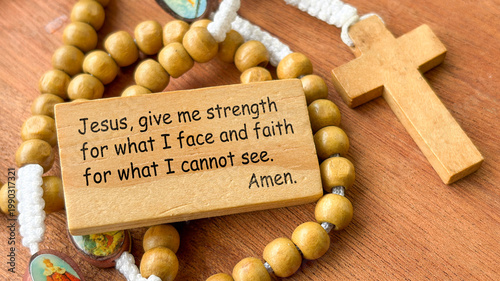 Prayer for strength text on wooden block with Holy Rosary background.