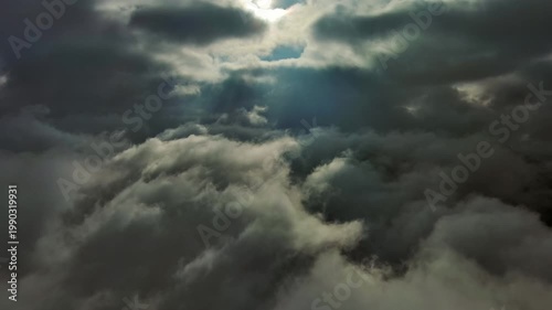Aerial high view of dramatic clouds and sun, flying in sunset clouds, 4k