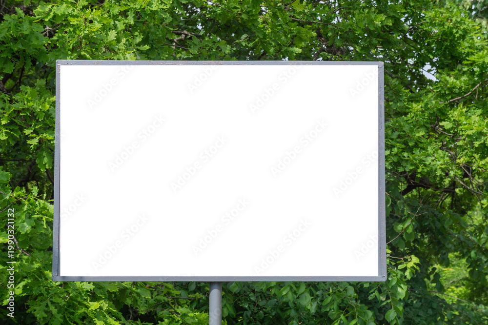 Fototapeta premium A white blank sign against a background of green park 