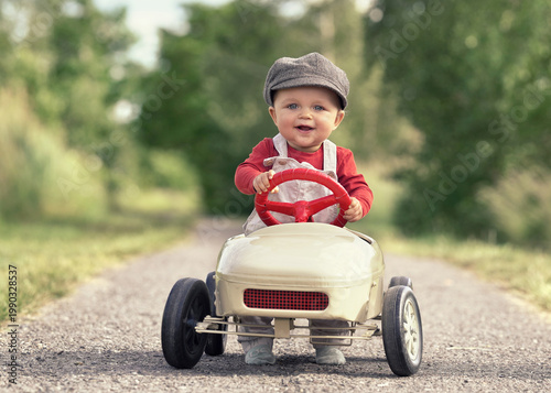 Happy Child Driving a Vintage Pedal Car on a Sunny Spring Day