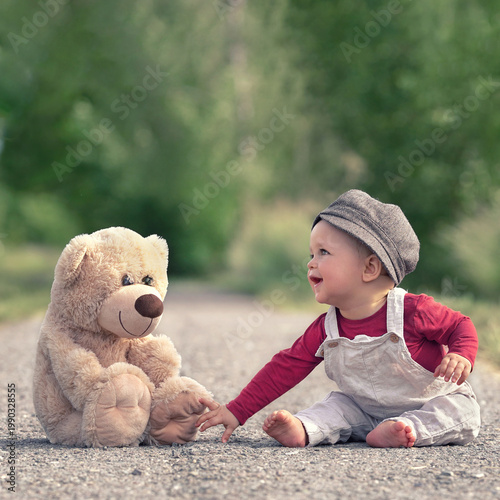 little boy playing with toy bear in spring season