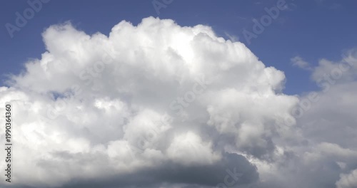 Time-lapse footage of white cumulus clouds in a blue sky.