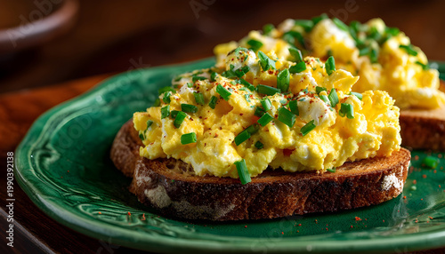 Diet scrambled eggs on toasted brioche bun on green plate