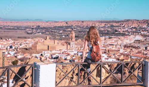Obraz na plátně young woman with leather backpack overlooking guadix skyline in spain, panoramic