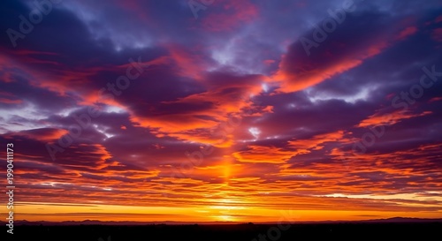 A dramatic red sunset sky filled with beautiful orange clouds creates a stunning nature landscape at dusk