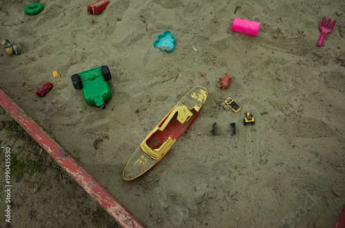 Children play with toys in a sand box on a sunny day in a park during the afternoon