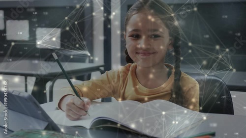 Student lowering pencil and writing in notebook to complete work while network overlay drifting