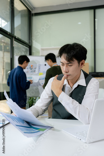 фотографія Stressed asian businessman working in the office