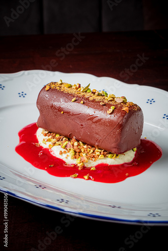 Foto Delightful chocolate dessert perched on raspberry sauce with crunchy pistachios