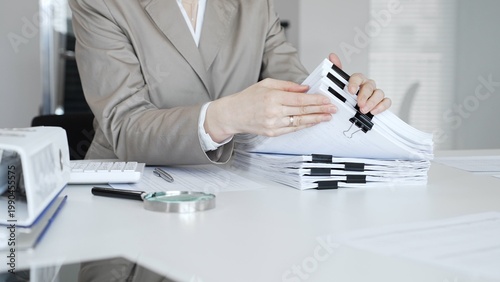 Εκτύπωση καμβά Businesswoman hands organizing stack of papers with binder clips, working on financial documents and official reports in office