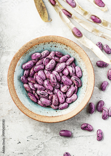 Photos Vibrant purple speckled runner bean seeds of Prize Winner variety (Phaseolus coccineus) in a rustic bowl