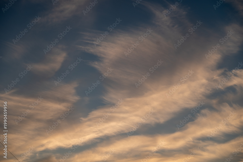 Fototapeta premium Dramatic sunset sky with vibrant dark clouds and power line silhouettes.