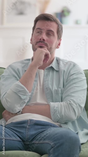 Young Man Thinking while Sitting on Sofa, Vertical Video