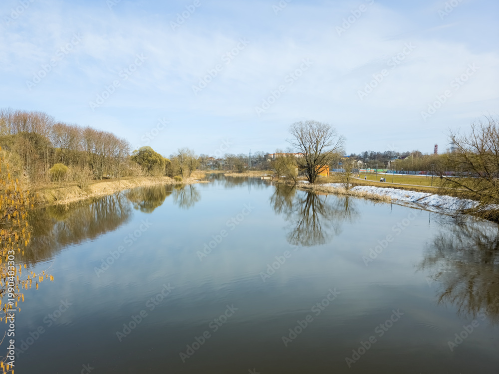 Fototapeta premium Tranquil River With Tree Reflections On Clear Spring Day