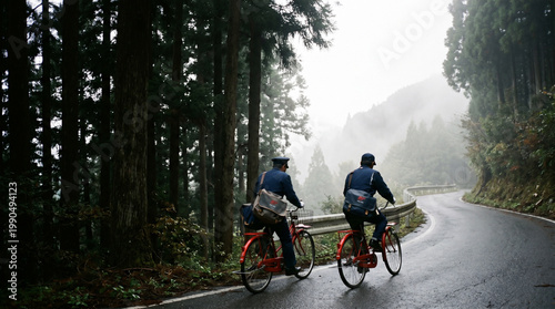 Cyclists Riding Through Misty Forest Mountain Road