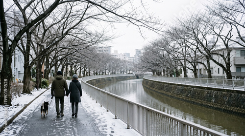 Winter walk along urban canal with couple and dog