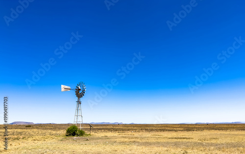 Windmill wind pump borehole in arid landscape