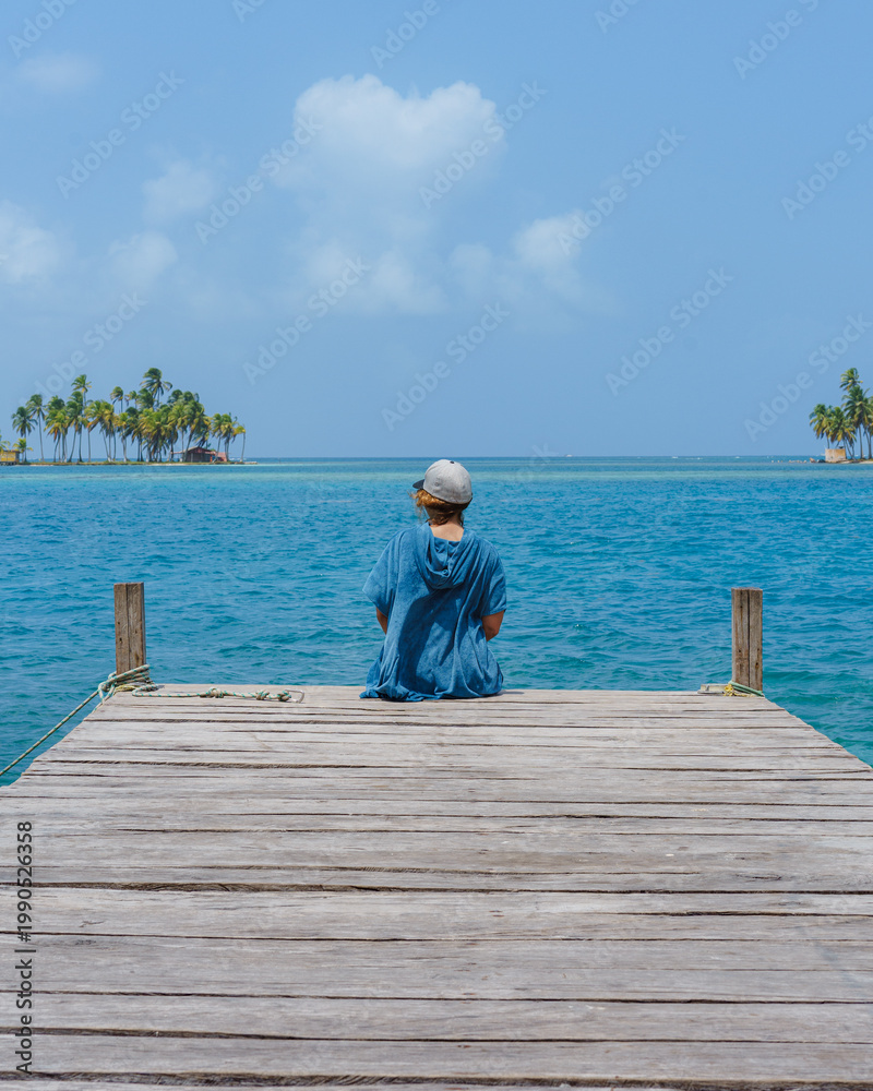 Fototapeta premium Woman sitting in a pier during summer vacation 