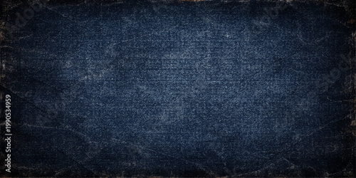 A closeup of dark blue denim fabric reveals a rough vintage textile pattern on a textured clothing material surface suitable for a fashion backdrop
