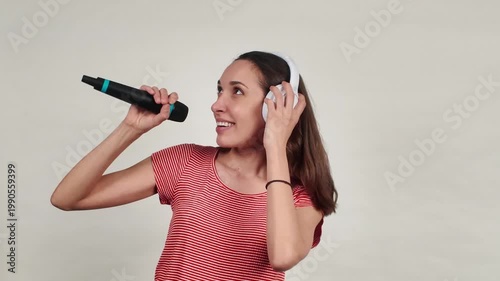 Happy young woman singing karaoke with headphones