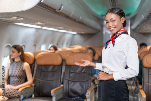 Obraz na plátne smiling air hostess welcoming passengers on board,flight attendant working in mo