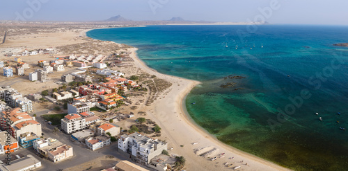 Aerial view of Sal Rei town,sandy beach and yacht moored in the green ocean, background volcanic mountain and desert,Sal Rei , Boa Vista island, Cape Verde.