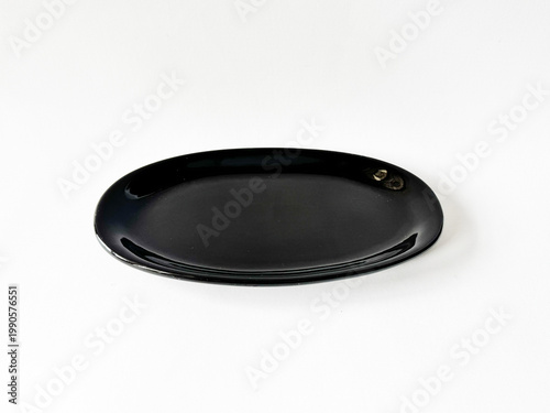 Black oval tray rests on clean white surface