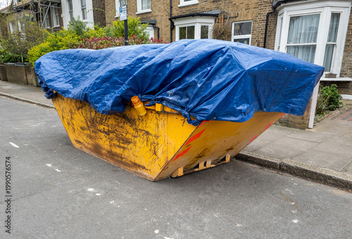 Tableau sur toile A residential construction waste skip with a blue cover on a suburban street