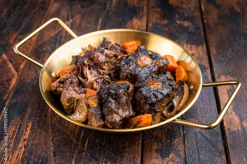 Foto Homemade beef oxtail ragout in pan, gelatin rich slow cooked meat with vegetable