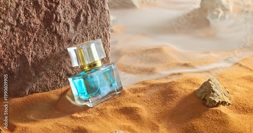 Unique amber perfumes in translucent glass bottle on sand.